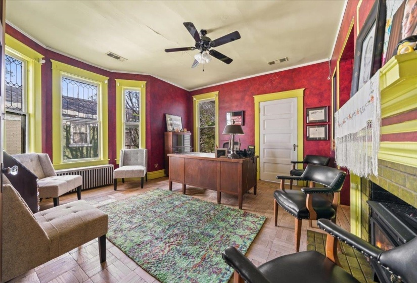 Office area featuring radiator heating unit, a ceiling fan, and parquet floors