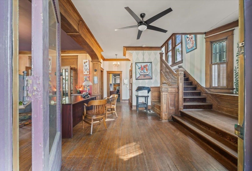 Office area featuring crown molding, dark wood-style floors, suspended lighting, and ceiling fan
