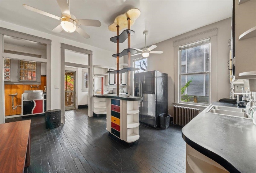 Kitchen with open shelves, a ceiling fan, refrigerator with ice dispenser, dark wood-style flooring, and radiator