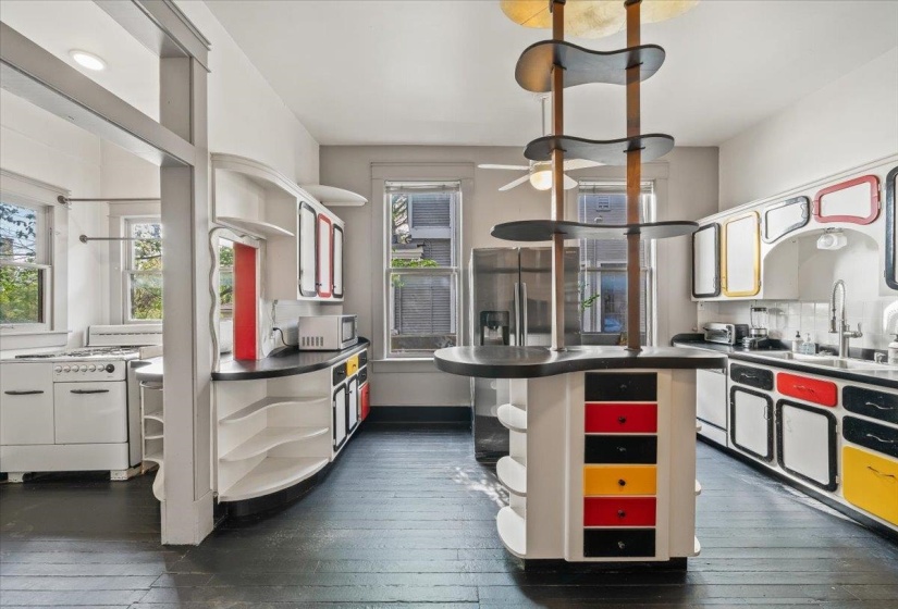 Kitchen featuring dark wood-type flooring, open shelves, dark countertops, and stainless steel appliances