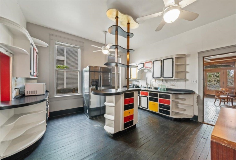 Kitchen with open shelves, ceiling fan, dark countertops, decorative backsplash, and stainless steel fridge