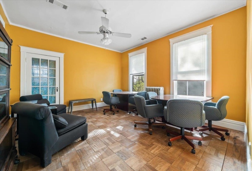 Home office featuring parquet flooring, ornamental molding, a ceiling fan, radiator heating unit, and healthy amount of natural light