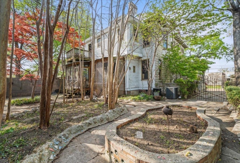 Back of house featuring a wooden deck and a patio