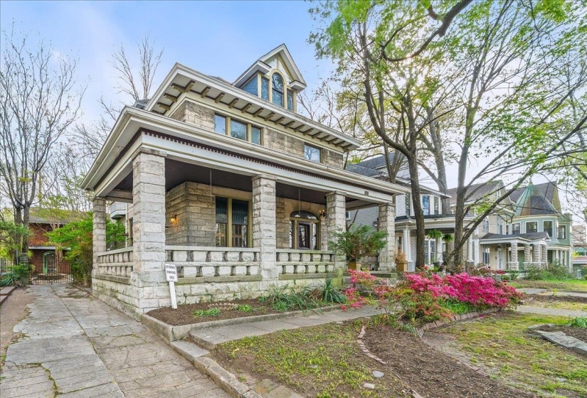 View of front of home with covered porch and stone siding