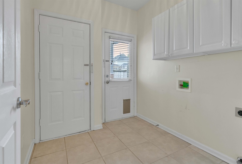 Laundry room with washer hookup, hookup for an electric dryer, light tile patterned floors, and cabinet space