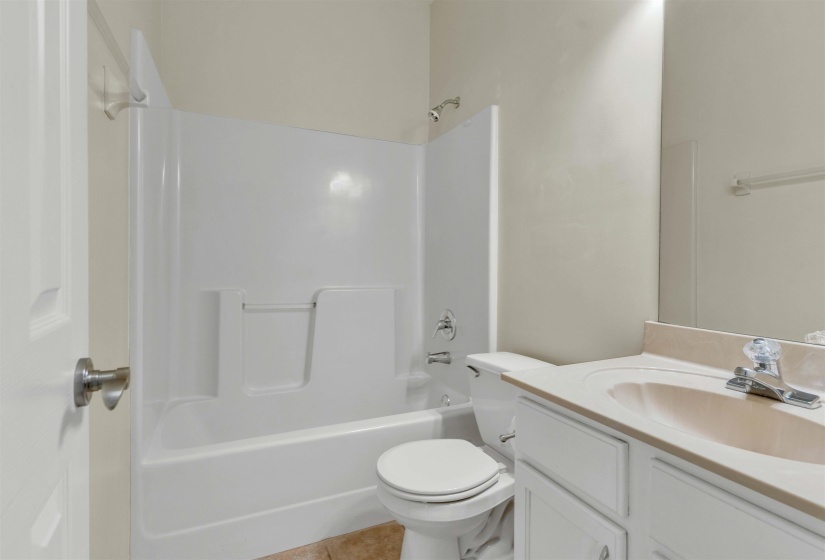 Bathroom featuring vanity, shower / bath combination, and light tile patterned floors