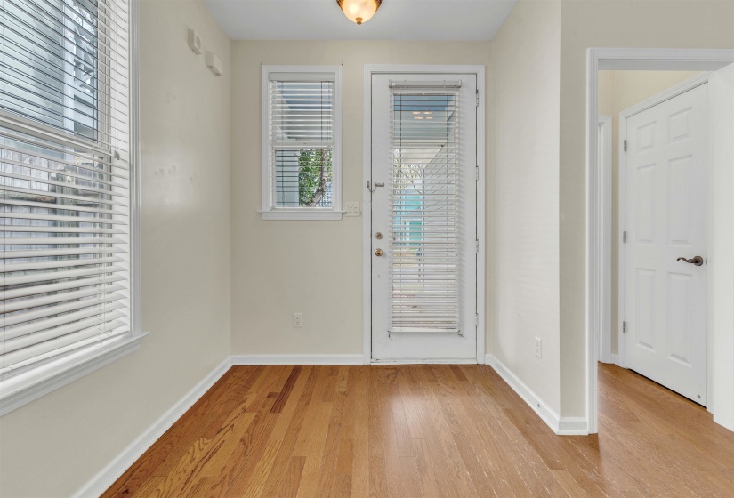Doorway with wood finished floors and baseboards