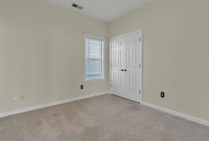 Unfurnished bedroom with light colored carpet and a closet