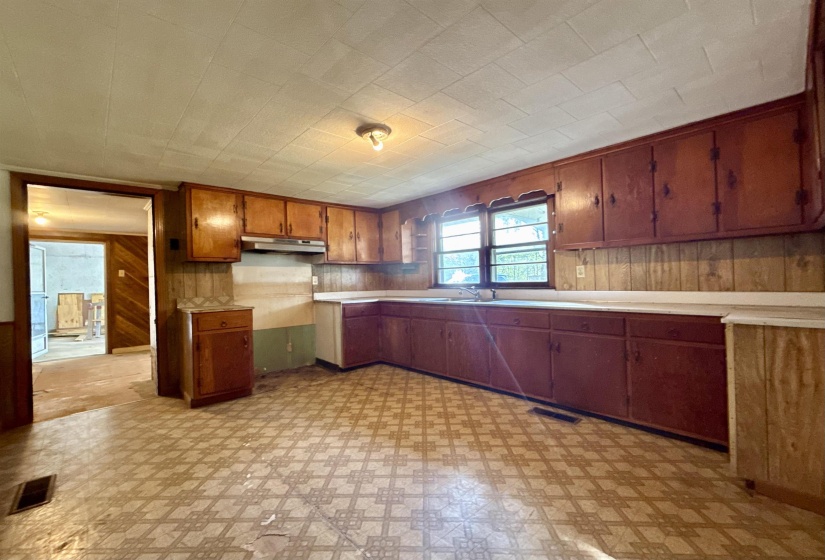 Kitchen with light floors, wood walls, light countertops, and wood finish cabinets