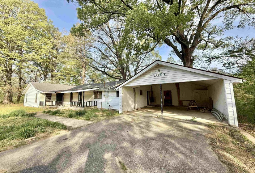 Ranch-style house featuring driveway, a porch, and an attached carport