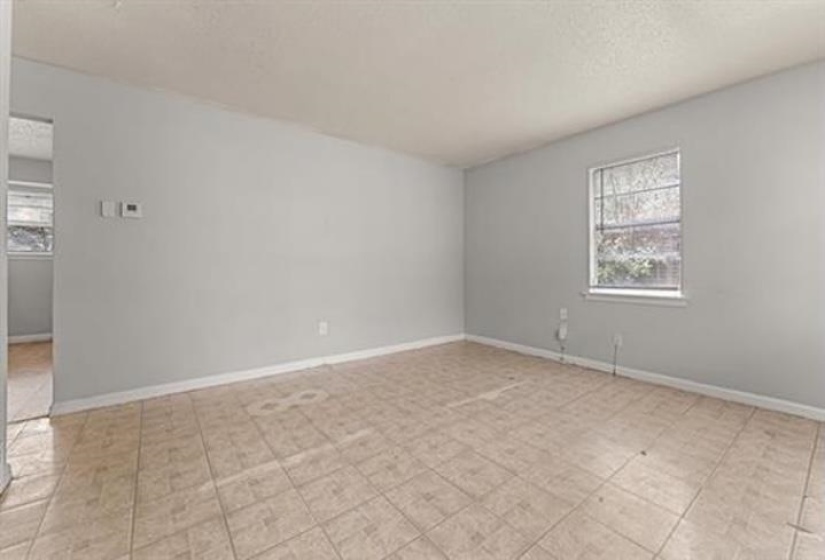 Unfurnished room with healthy amount of natural light and a textured ceiling