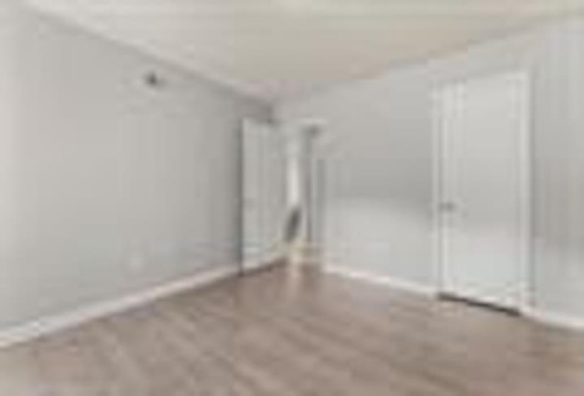 Unfurnished bedroom with wood finished floors and baseboards