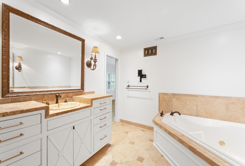 Bathroom with travertine stone whirlpool tub, double vanities and walk-in shower