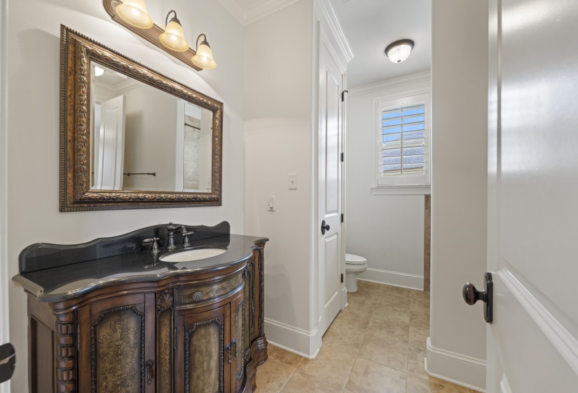 Bathroom with ornamental molding, vanity, and light tile patterned floors
