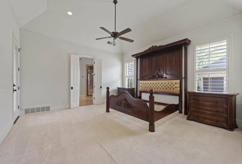 Bedroom featuring lofted ceiling, light colored carpet, multiple windows, a ceiling fan, and recessed lighting