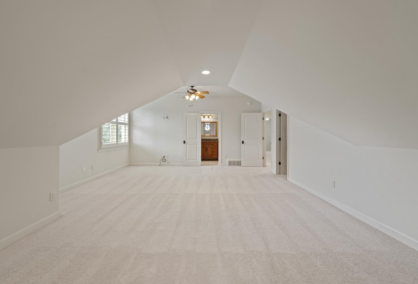 Additional living space featuring light colored carpet, ceiling fan, and recessed lighting