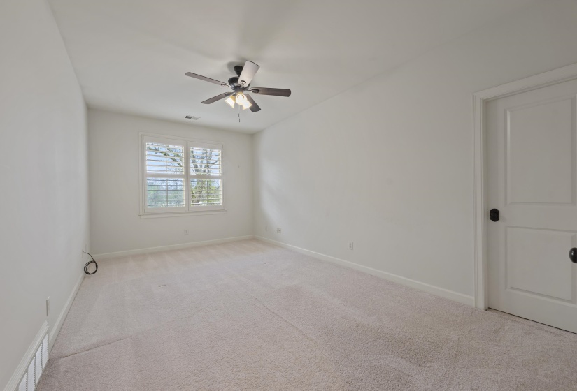 Spare room featuring light carpet and ceiling fan