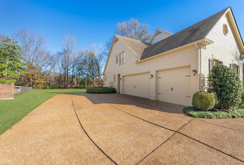 View of side of home featuring brick siding, concrete driveway, a shingled roof, and a yard