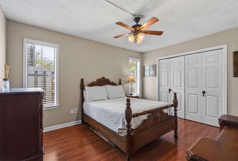 Bedroom featuring dark wood finished floors, a textured ceiling, ceiling fan, and a closet
