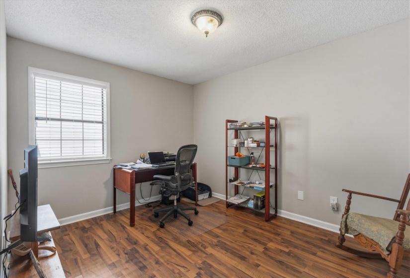 Office with dark wood-style floors and a textured ceiling