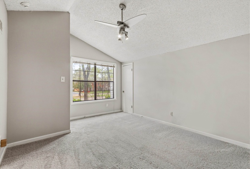 Empty room featuring a ceiling fan and light carpet