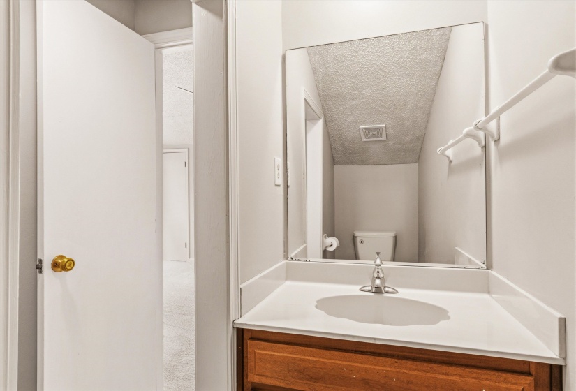 Half bath with a textured ceiling and vanity