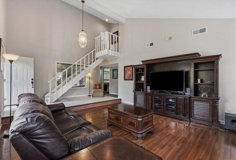 Living room with dark wood finished floors and vaulted ceiling