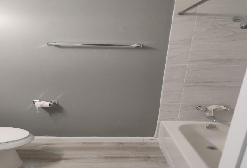 Bathroom with shower / tub combination and light wood finished floors