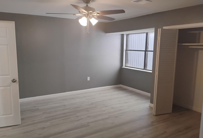 Unfurnished bedroom featuring light wood-style floors, a closet, and ceiling fan