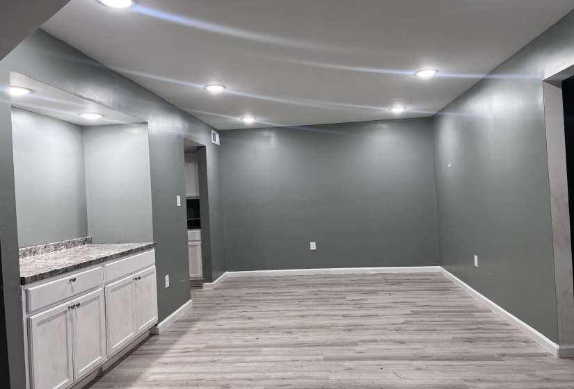 Interior space featuring light wood-style flooring, recessed lighting, white cabinetry, and light stone counters