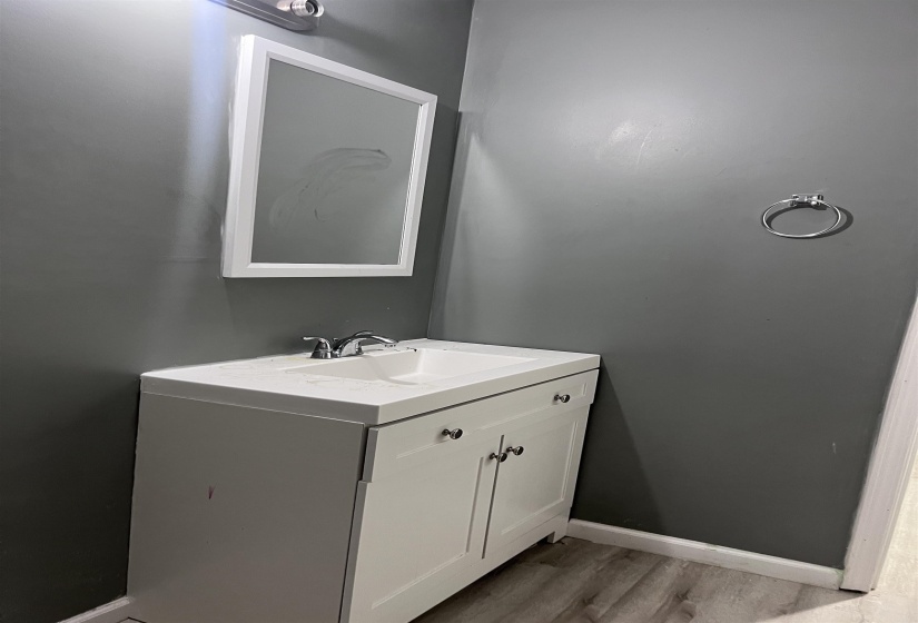 Half bathroom featuring vanity and light wood-type flooring