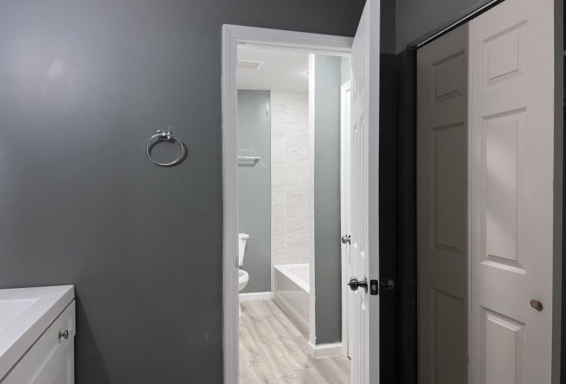Full bath featuring vanity, light wood finished floors, and shower / tub combination