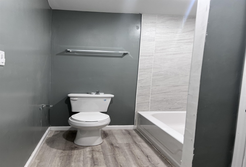 Full bathroom with toilet and light wood-type flooring