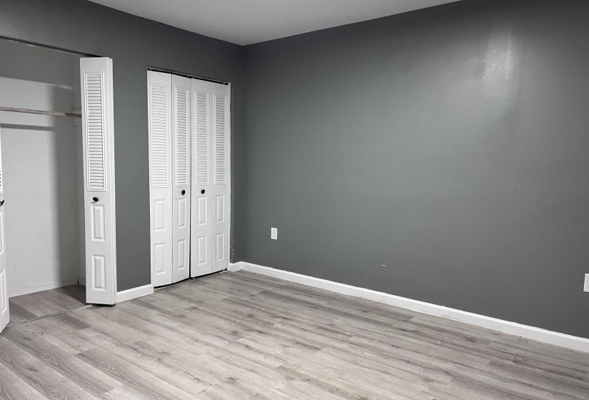 Unfurnished bedroom featuring multiple closets and light wood-type flooring