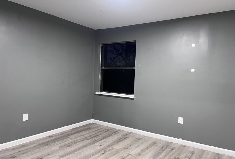Empty room featuring baseboards and light wood-type flooring