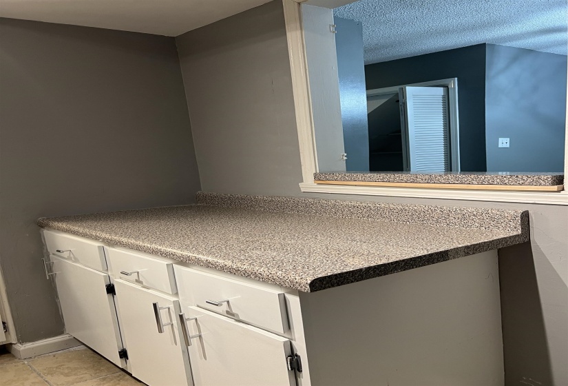 Bathroom with light tile patterned flooring and a textured ceiling