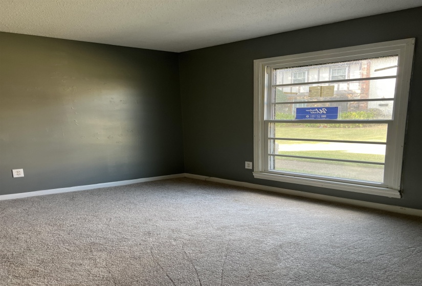 Empty room with carpet and a textured ceiling