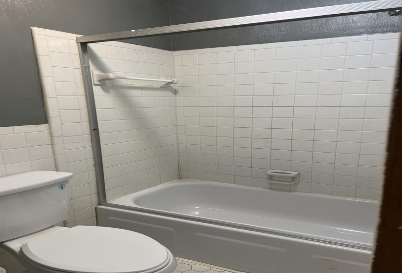 Full bathroom with bathing tub / shower combination, tile walls, and tile patterned floors
