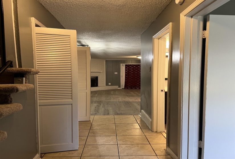 Hall featuring a textured ceiling and light tile patterned flooring