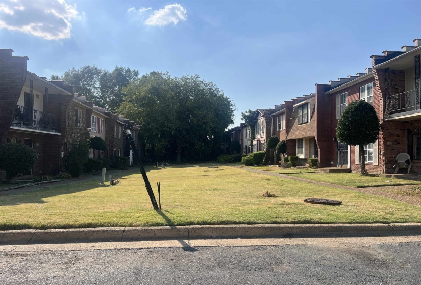 View of property's community featuring a balcony, a yard, and a residential view