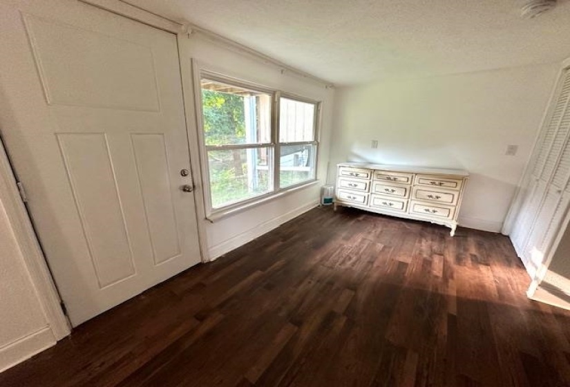Unfurnished bedroom featuring a textured ceiling and dark hardwood / wood-style floors