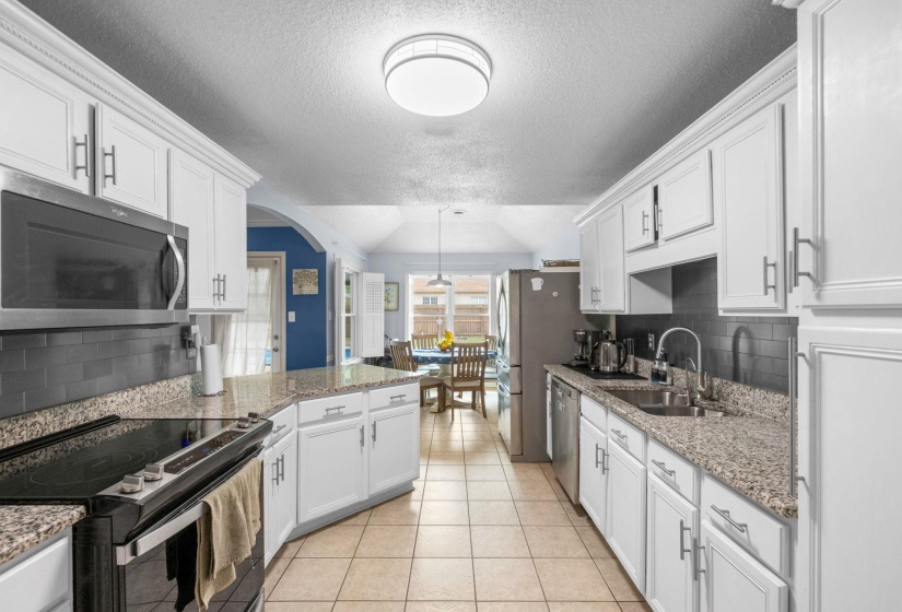 Bright and updated kitchen featuring granite countertops, white cabinetry, stainless steel appliances, abundant prep space, and a functional layout. Perfect for everyday living and entertaining, with timeless finishes and plenty of storage throughout. ???