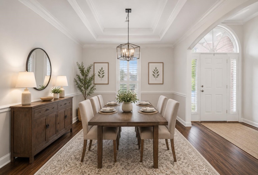 Elegant formal dining room featuring a stunning tray ceiling, rich hardwood floors, abundant natural light, and designer lighting. Perfect for holiday gatherings, dinner parties, or everyday entertaining in style & comfort. Image has been virtually staged