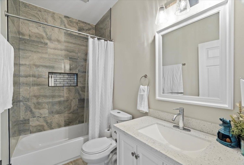 Full bathroom with vanity, shower / tub combo, and toilet