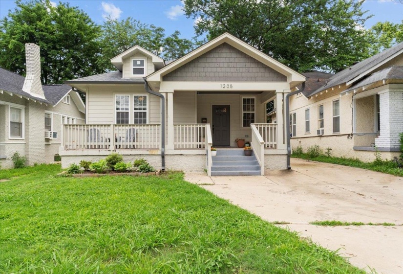 View of front of home featuring a front lawn, a porch, and cooling unit