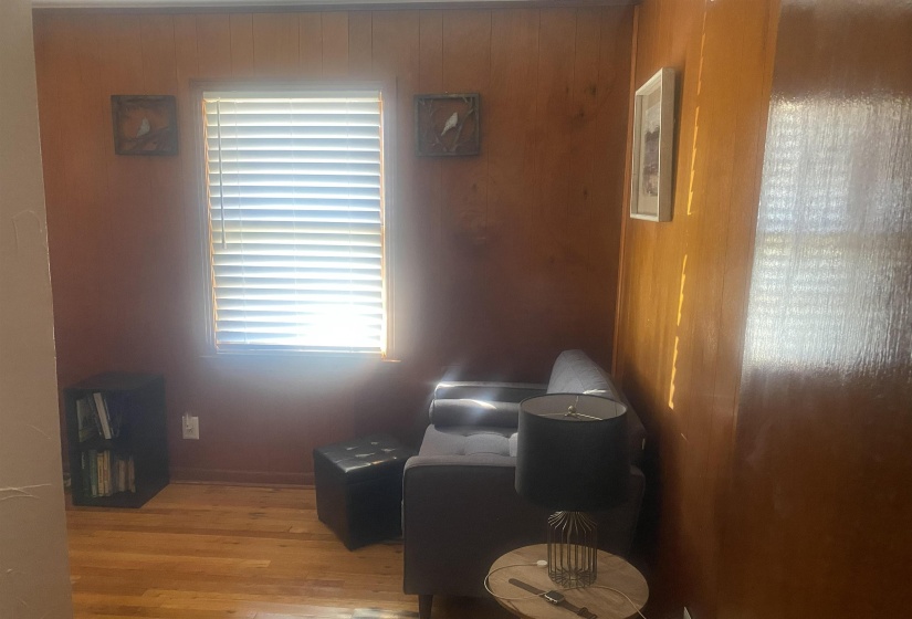 Living area with wood finished floors and wooden walls