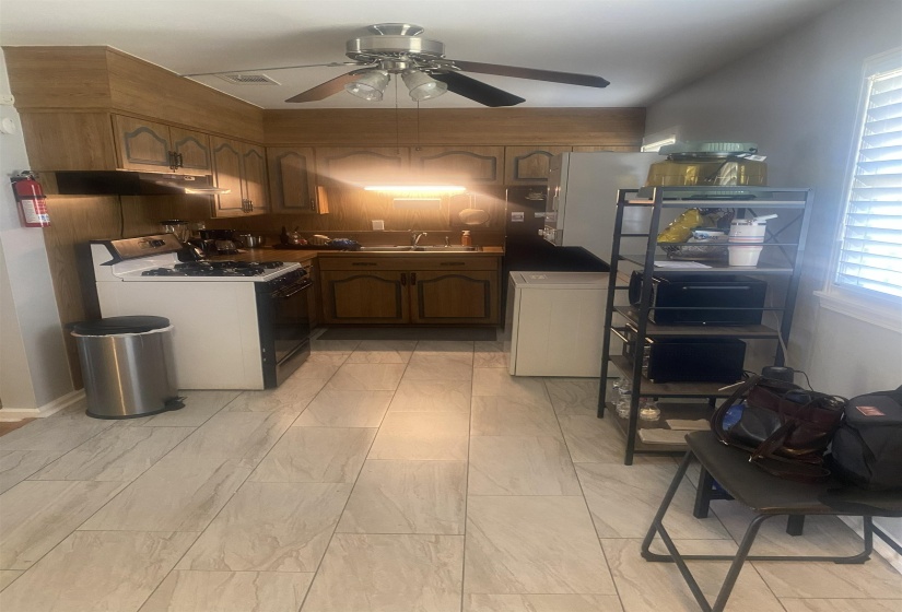 Kitchen featuring white range with gas stovetop, a ceiling fan, and dark countertops