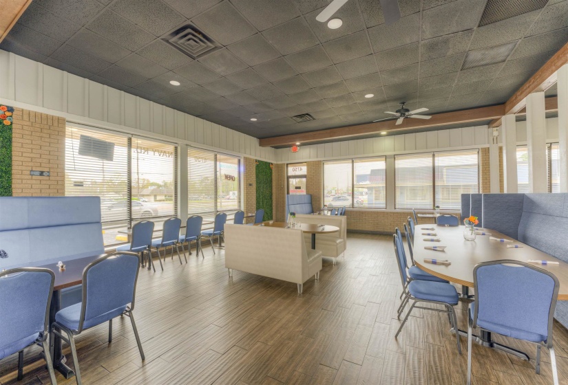 Living area featuring wood finished floors, brick wall, and a paneled ceiling