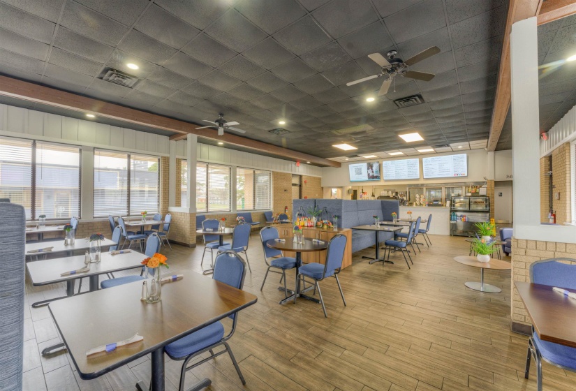 Dining room featuring a drop ceiling, ceiling fan, wood finished floors, and healthy amount of natural light