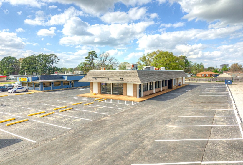 View of commercial property featuring uncovered parking
